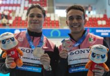 two swimmers holding medals