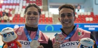 two swimmers holding medals