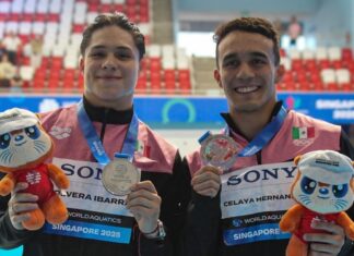 two swimmers holding medals