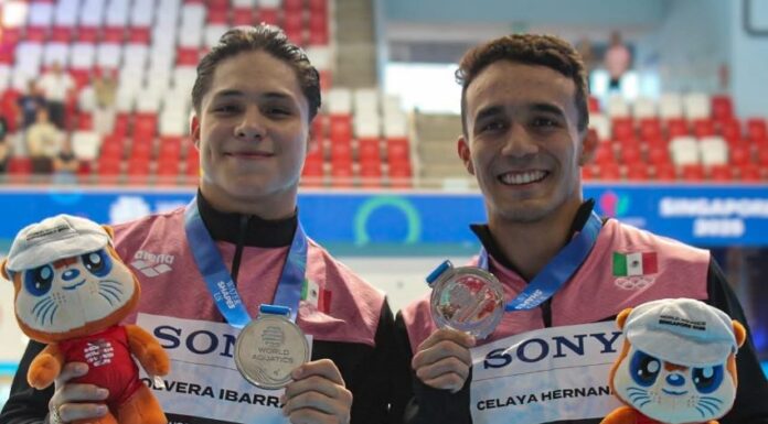 two swimmers holding medals