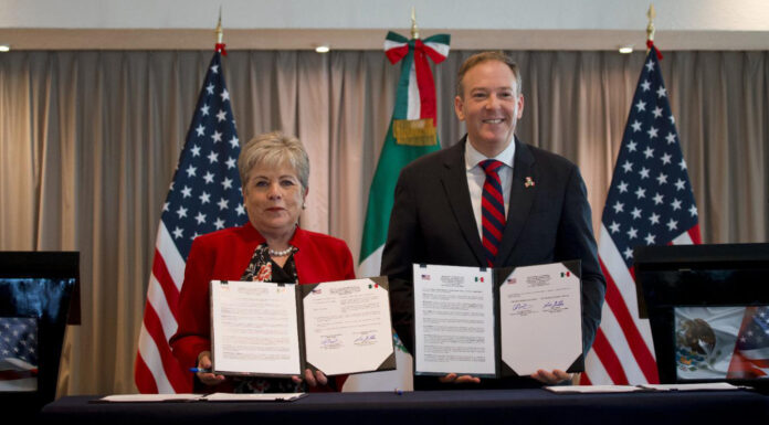 Alicia Bárcena and Zeldin hold up copies of a signed agreement to fund sewage treatment for the Tijuana River