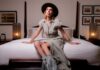 A woman sat on a bed in a luxury hotel