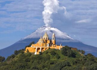 Nuestra Señora de los Remedios church in Cholula, Puebla, with Popocatépetl volcano smoking behind