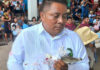 Man in white shirtholding a caiman