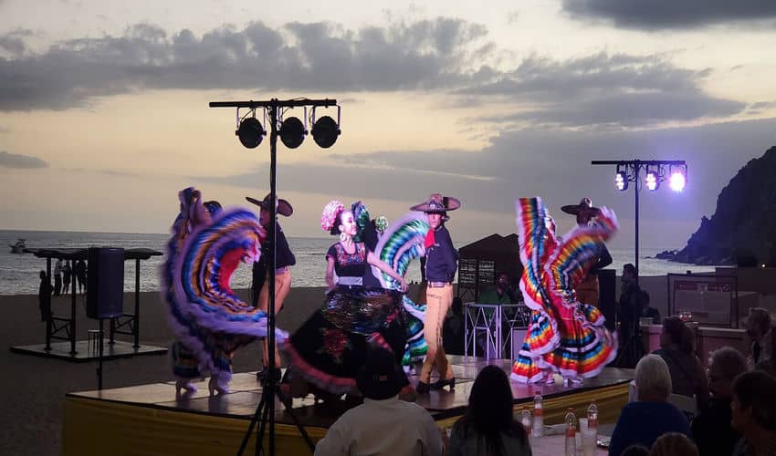 Un groupe de danseurs dans des robes mexicaines traditionnelles colorées et Zooraros effectue des crépuscules sur une plate-forme en plein air sur une plate-forme en plein air.