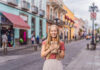 A blond woman holds churros in a Mexican street