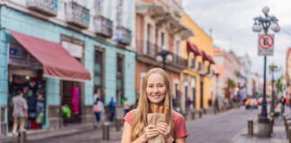 A blond woman holds churros in a Mexican street