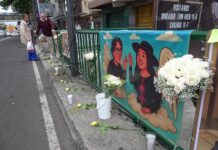 A streetside altar in Mexico City with flowers and a banner honoring two aides to Mayor Clara Brugada who were killed in May
