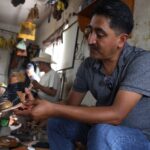 man crafting a sandal