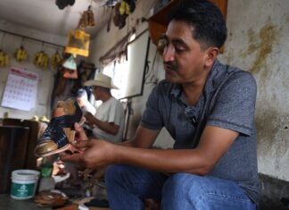 man crafting a sandal