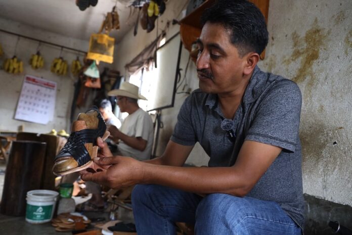man crafting a sandal