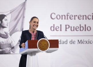President Claudia Sheinbaum at a podium in front of the worlds "Conferencia del Pueblo"