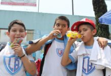Three schoolboys drinking sugared drinks