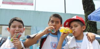 Three schoolboys drinking sugared drinks