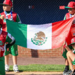 kids in baseball uniform holding flag