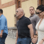 Jeff Bezos and Lauren Sanchez hold hands while walking in a paparazzi photo