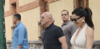 Jeff Bezos and Lauren Sanchez hold hands while walking in a paparazzi photo