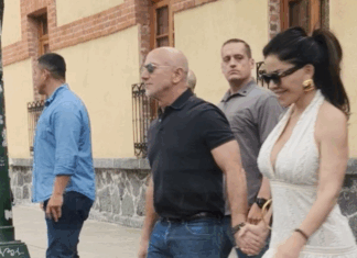 Jeff Bezos and Lauren Sanchez hold hands while walking in a paparazzi photo