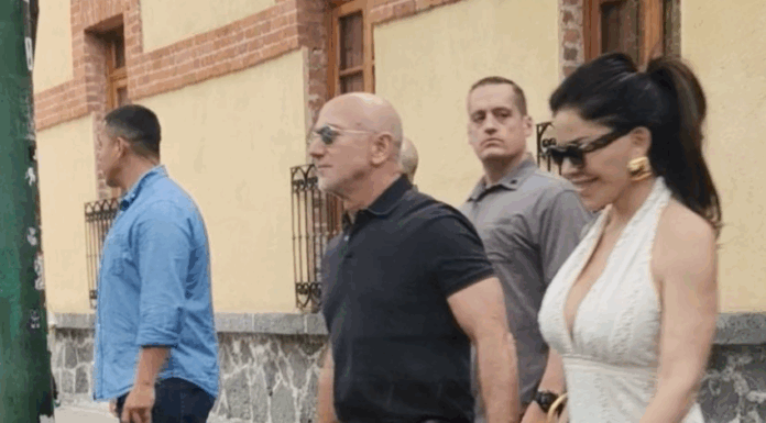 Jeff Bezos and Lauren Sanchez hold hands while walking in a paparazzi photo