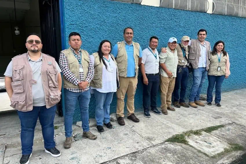 about a dozen people standing against a wall in Guatemala.