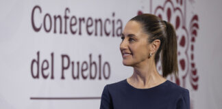 Sheinbaum in front of a banner reading "conferencia del pueblo"
