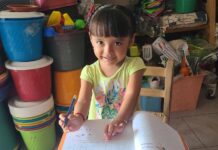 A young girl writing in a textbook