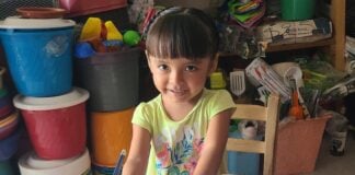 A young girl writing in a textbook