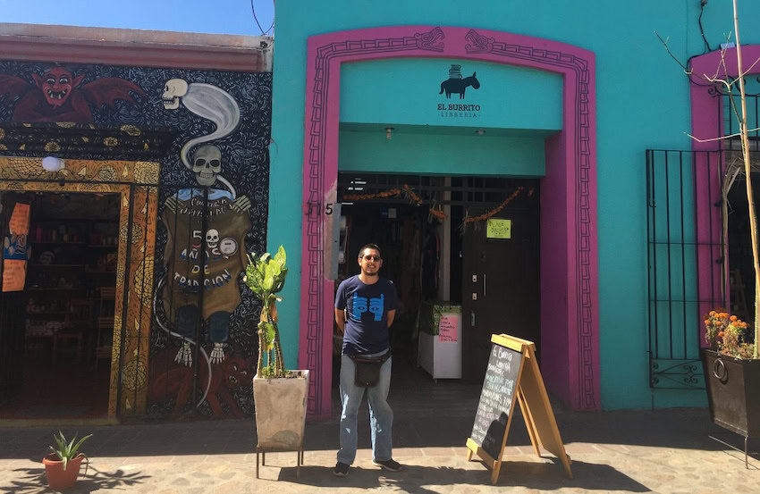 A man standing in front of a bookstore in Oaxaca city