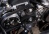 A closeup shot of auto parts: a car's timing belt and engine