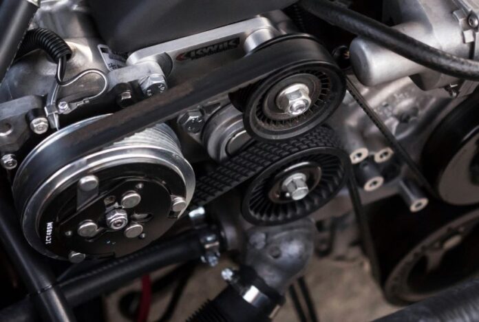 A closeup shot of auto parts: a car's timing belt and engine