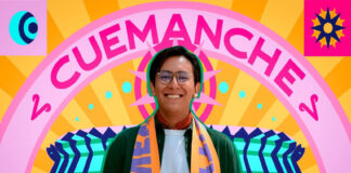 Photo of designer Mario Cortés smiling warmly, wearing glasses and an orange and purple FIFA Mexico City official scarf. The photo is set against a vibrant, stylized graphic background that features his artistic name, "CUEMANCHE," in large pink letters above a colorful sunburst design.