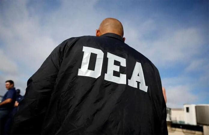 A bald white man in a DEA jacket