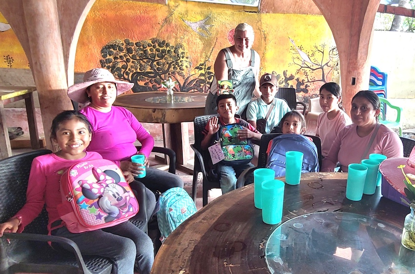 An Indigenous Mexican family receiving new bags and books for school