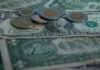 peso coins on top of dollar bills
