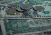 peso coins on top of dollar bills