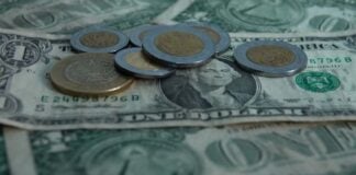 peso coins on top of dollar bills