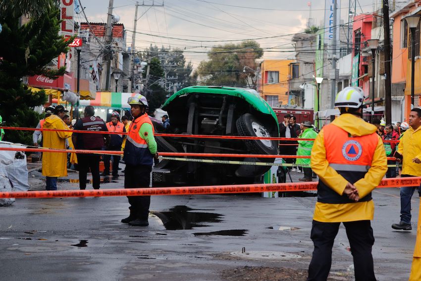 Jarritos truck sticks out from a sinkhole on a street in Mexico City