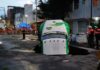 Jarritos truck sticks out from a sinkhole on a street in Mexico City