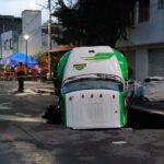 Jarritos truck sticks out from a sinkhole on a street in Mexico City