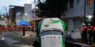 Jarritos truck sticks out from a sinkhole on a street in Mexico City
