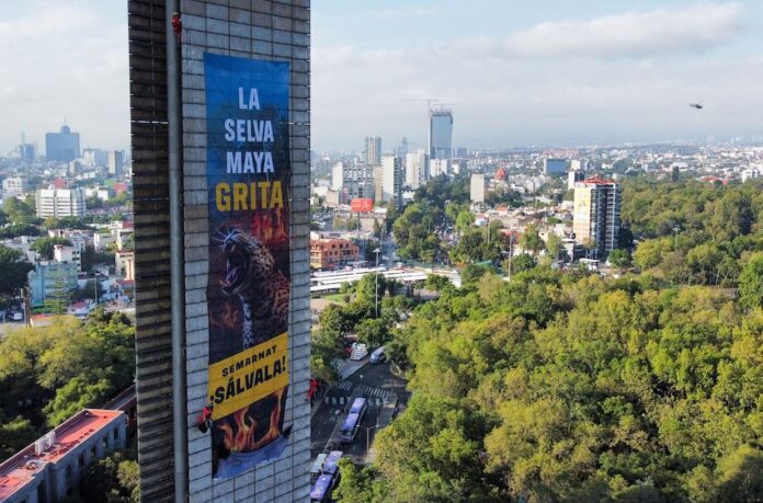 Greenpeace banner hanging from Estela de Luz that says 
