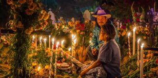 An elderly couple at a grave during Day of the Dead in Oaxaca