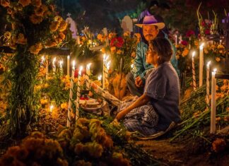 An elderly couple at a grave during Day of the Dead in Oaxaca