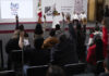 Reporters in the press pool raise their hands at President Sheinbaum's morning press conference