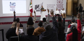 Reporters in the press pool raise their hands at President Sheinbaum's morning press conference
