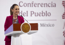 "Conferencia del Pueblo" reads a banner behind President Sheinbaum as she stands at the podium of her morning press conference