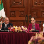 President Sheinbaum and Canada PM Mark Carney sit at a table in the National Palace with Canadian and Mexican flags