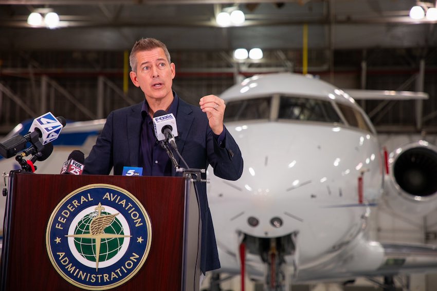 Sean Duffy speaking in front of an airplane