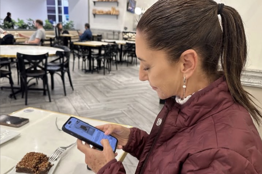Sheinbaum reading something on her cell phone