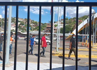 Brown men walk through the US-Mexico border in Nogales